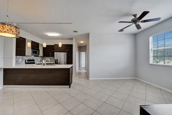 a view of kitchen with stainless steel appliances kitchen island granite countertop a refrigerator and a sink