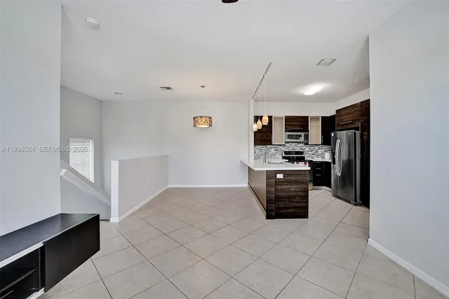a large white kitchen with a stove a sink dishwasher and a refrigerator