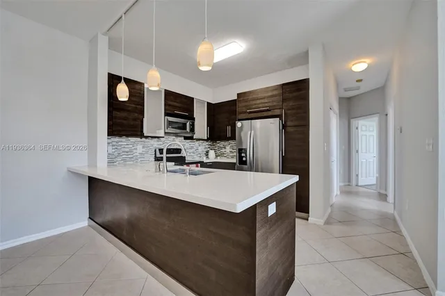 a kitchen with kitchen island granite countertop a stove top oven a sink dishwasher a dining table and chairs with wooden floor