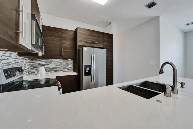 a kitchen with a sink and a refrigerator