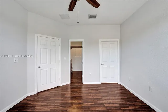 a view of empty room with wooden floor