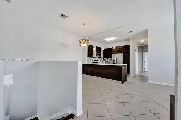 a large white kitchen with a sink and cabinets
