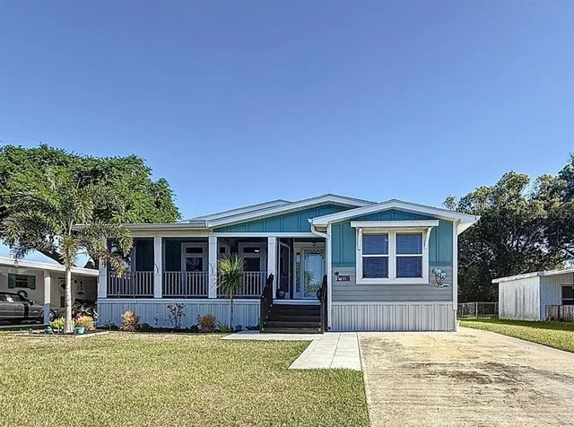 a view of a house with a big yard and large tree