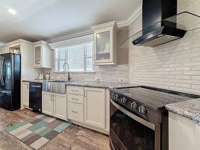 a kitchen with granite countertop a stove sink and cabinets