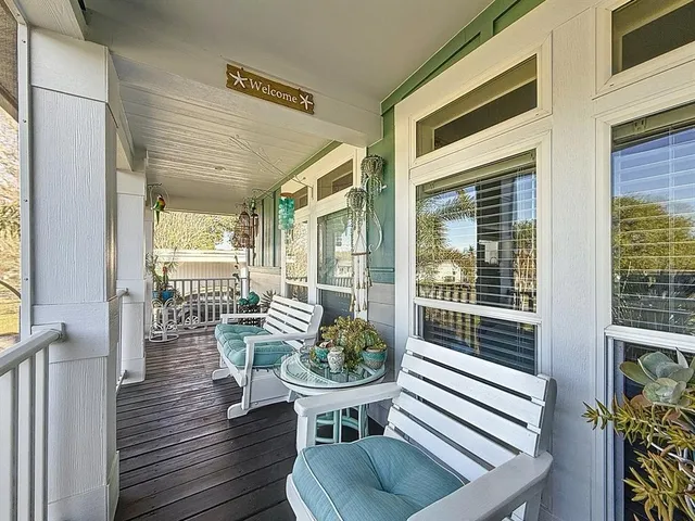 a view of a balcony with chairs and wooden floor