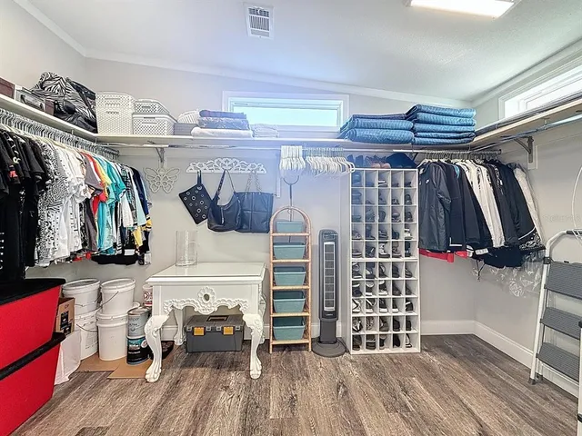 a view of walk in closet with clothes and shoes