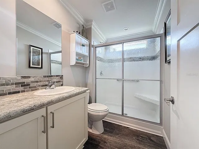 a bathroom with a granite countertop sink toilet and mirror