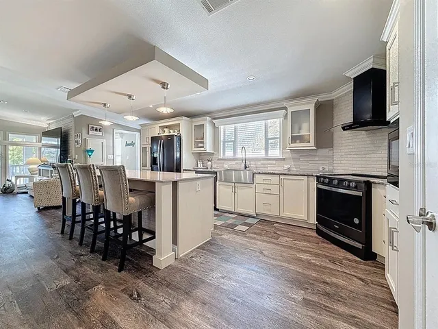 a kitchen with cabinets a sink and chairs in it