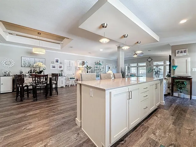 a large white kitchen with lots of counter space and dining table