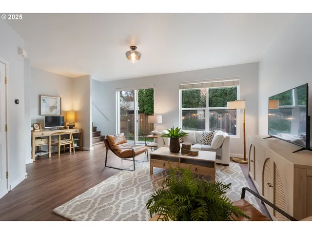 a living room with furniture a flat screen tv and floor to ceiling window