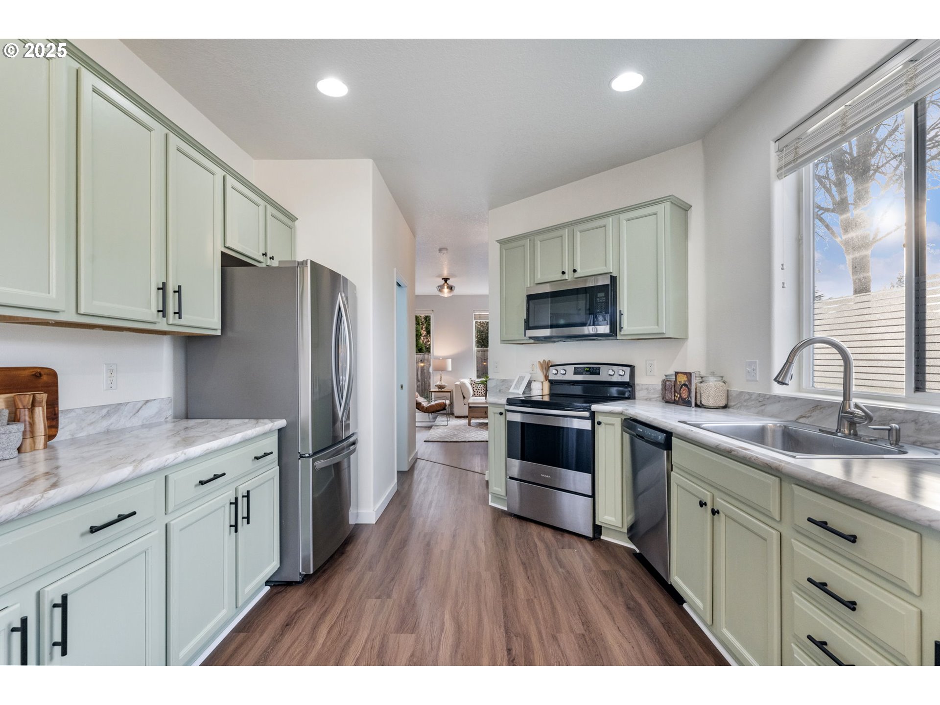 18186 Southwest Strathmoor Street Beaverton, OR 97007 - Photo 10 of 35 a kitchen with stainless steel appliances granite countertop a refrigerator stove a sink dishwasher and microwave with wooden cabinets