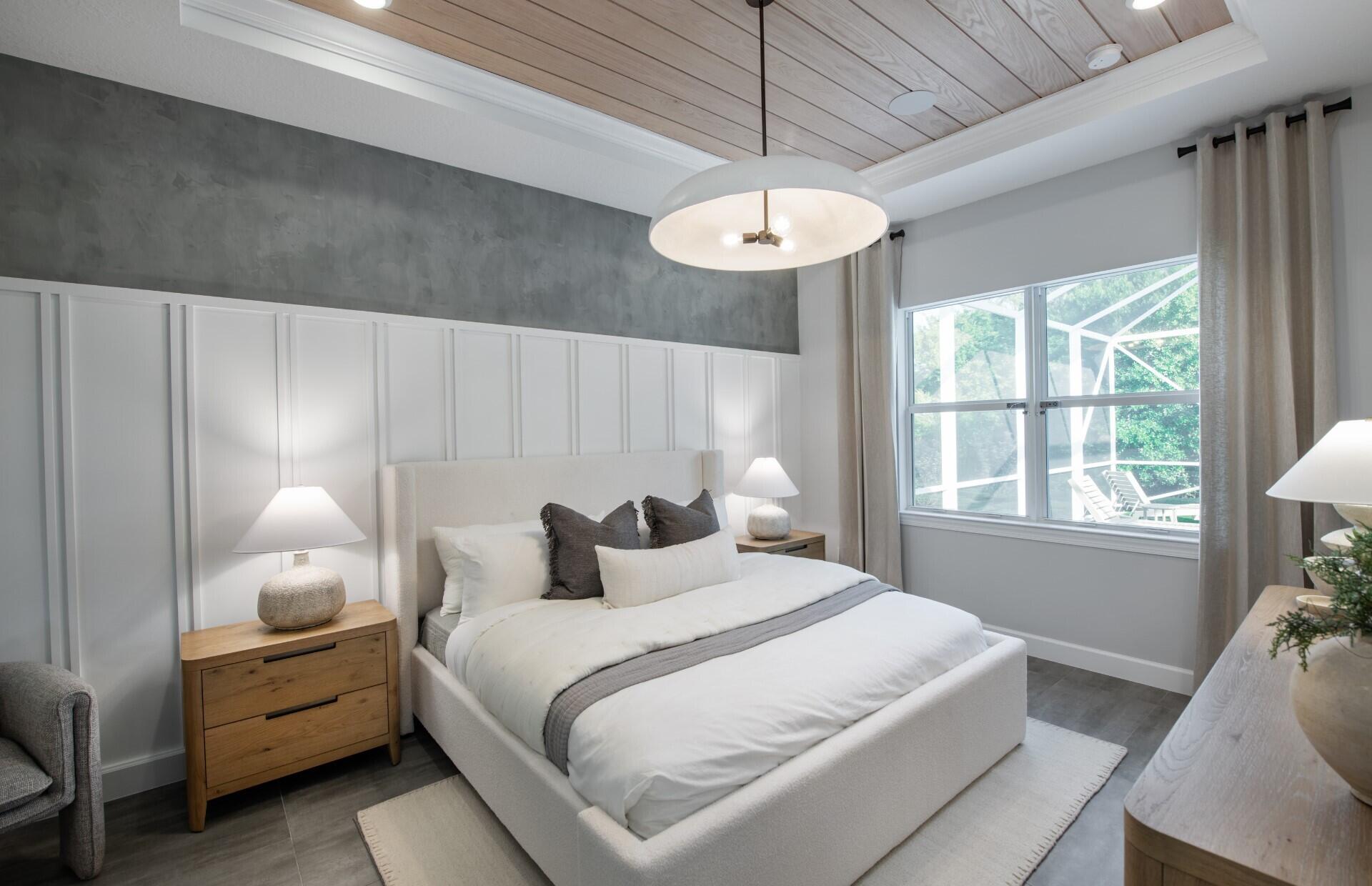 10231 Southwest Highpointe Drive, Unit ASHBY 281 Stuart, FL 34997 - Photo 12 of 33 a bedroom with a bed and a chandelier