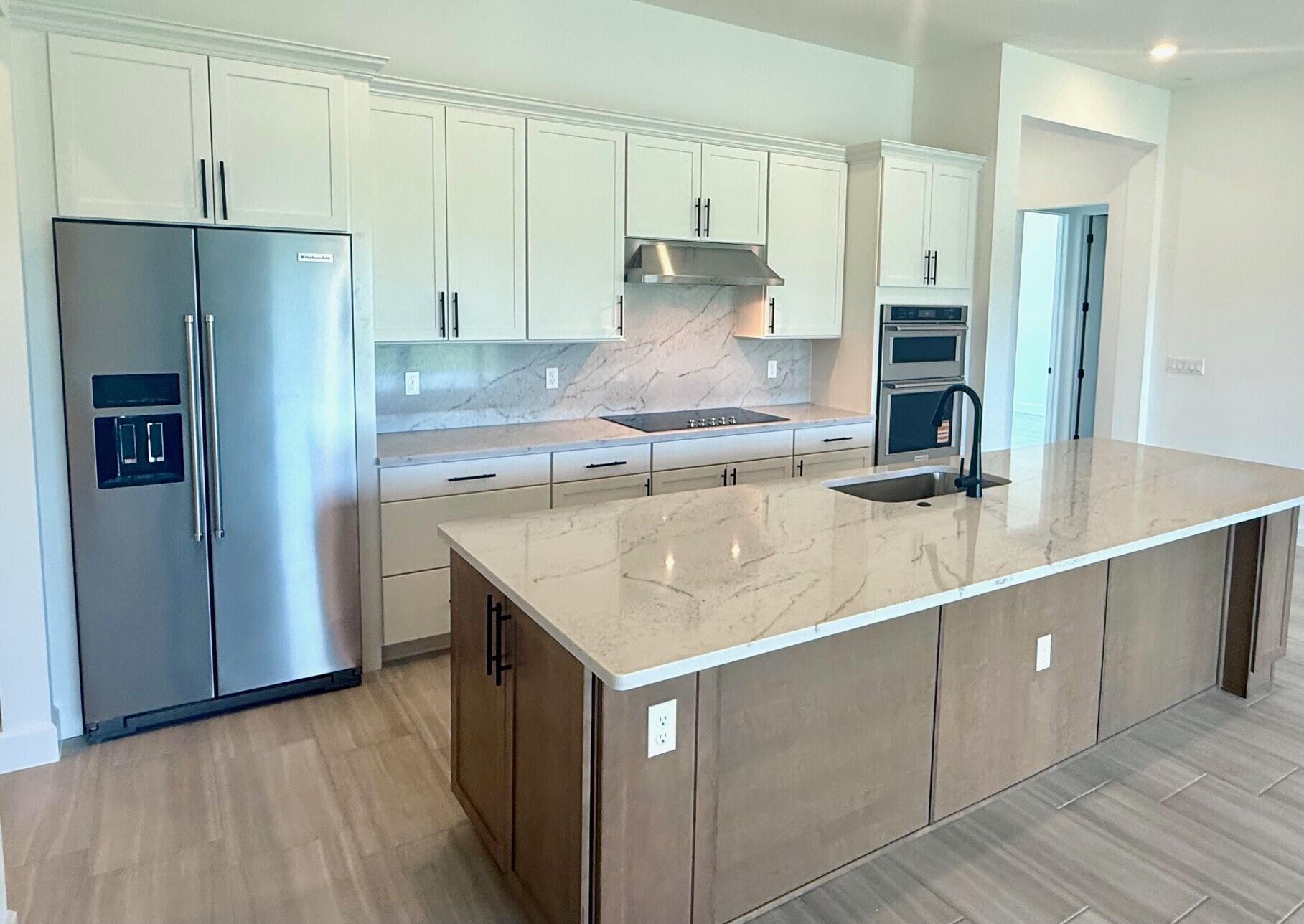 10231 Southwest Highpointe Drive, Unit ASHBY 281 Stuart, FL 34997 - Photo 9 of 33 a kitchen with stainless steel appliances granite countertop a refrigerator and a sink