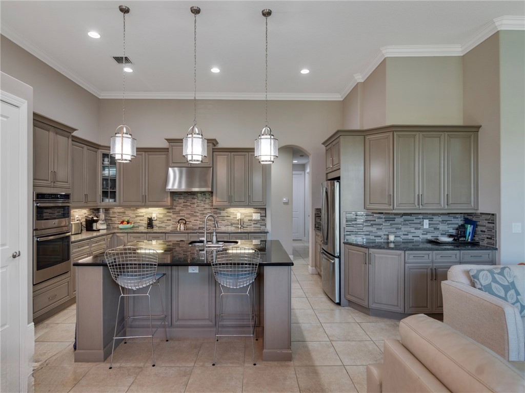 8260 Halbert Lane Vero Beach, FL 32968 - Photo 12 of 36 a kitchen with kitchen island a sink stainless steel appliances and cabinets