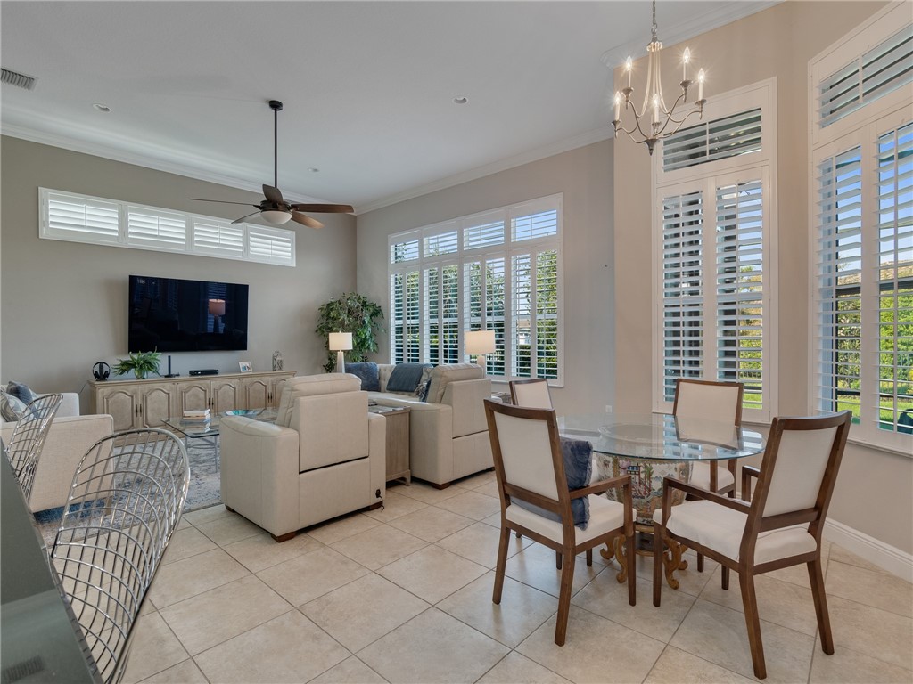 8260 Halbert Lane Vero Beach, FL 32968 - Photo 13 of 36 a living room with furniture a flat screen tv and a chandelier