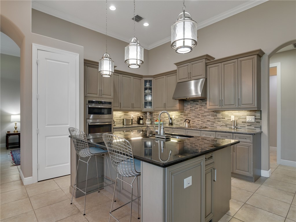 8260 Halbert Lane Vero Beach, FL 32968 - Photo 6 of 36 a kitchen with stainless steel appliances granite countertop a sink and a refrigerator