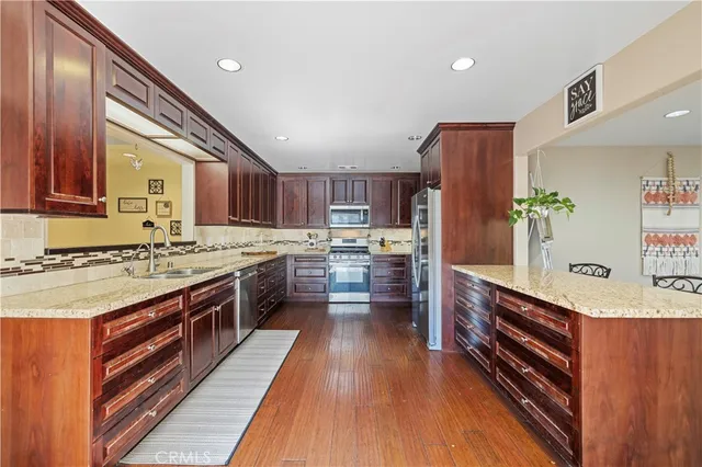 a open kitchen with stainless steel appliances granite countertop a stove refrigerator and cabinets