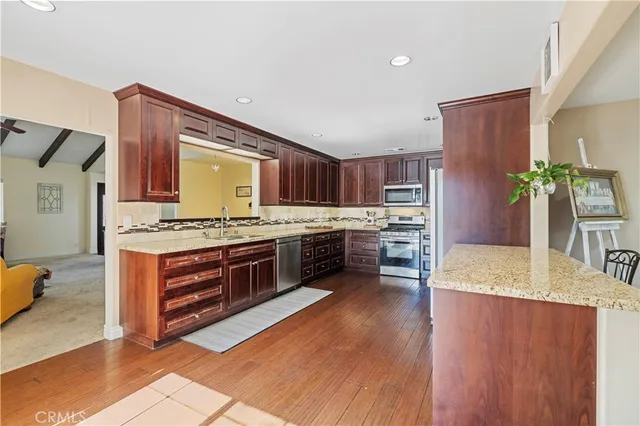 a kitchen with stainless steel appliances granite countertop a stove a sink dishwasher and a refrigerator