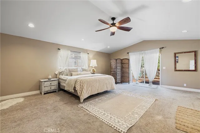 a spacious bedroom with a bed and ceiling fan