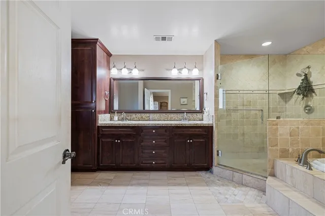 a bathroom with a tub a sink and glass door