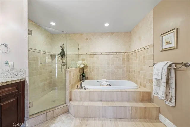 a spacious bathroom with a bathtub shower sink double and mirror