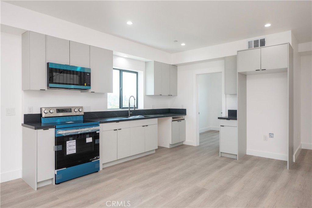 1571 Ricardo Street, Unit 2 Los Angeles, CA 90033 - Photo 2 of 29 a kitchen with a refrigerator and a stove top oven