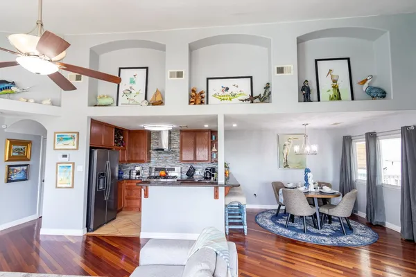 a living room with furniture kitchen view and a window