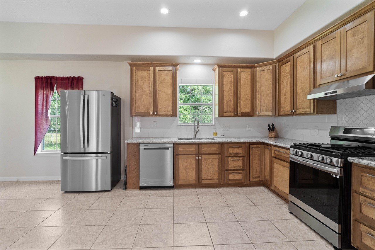 1019 Deer Field Court Weimar, TX 78962 - Photo 21 of 50 a kitchen with stainless steel appliances granite countertop a refrigerator sink and stove