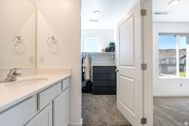 1693 Devils Gdn Lane Washington, UT 84780 - Photo 29 of 64 Bathroom vanity with a rectangular undermount sink, chrome faucet, and light-colored countertop