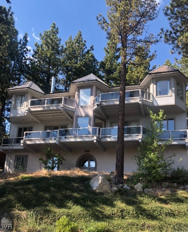 a front view of a house with a garden and lake view