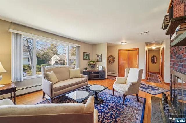 a living room with furniture a flat screen tv and a large window