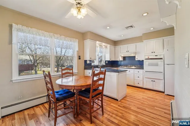a kitchen with a dining table chairs and white cabinets
