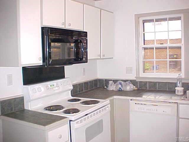 5509 McCormick Road Durham, NC 27713 - Photo 2 of 7 a kitchen with granite countertop a stove sink and cabinets