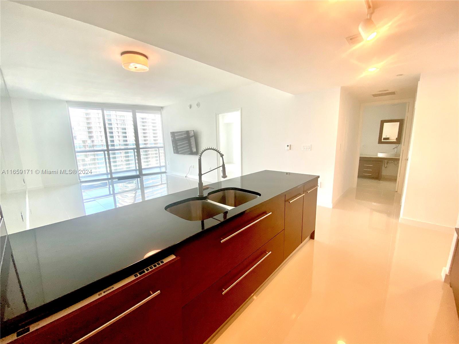 475 Brickell Avenue, Unit 4812 Miami, FL 33131 - Photo 2 of 20 a kitchen with stainless steel appliances sinks a stove and a large window