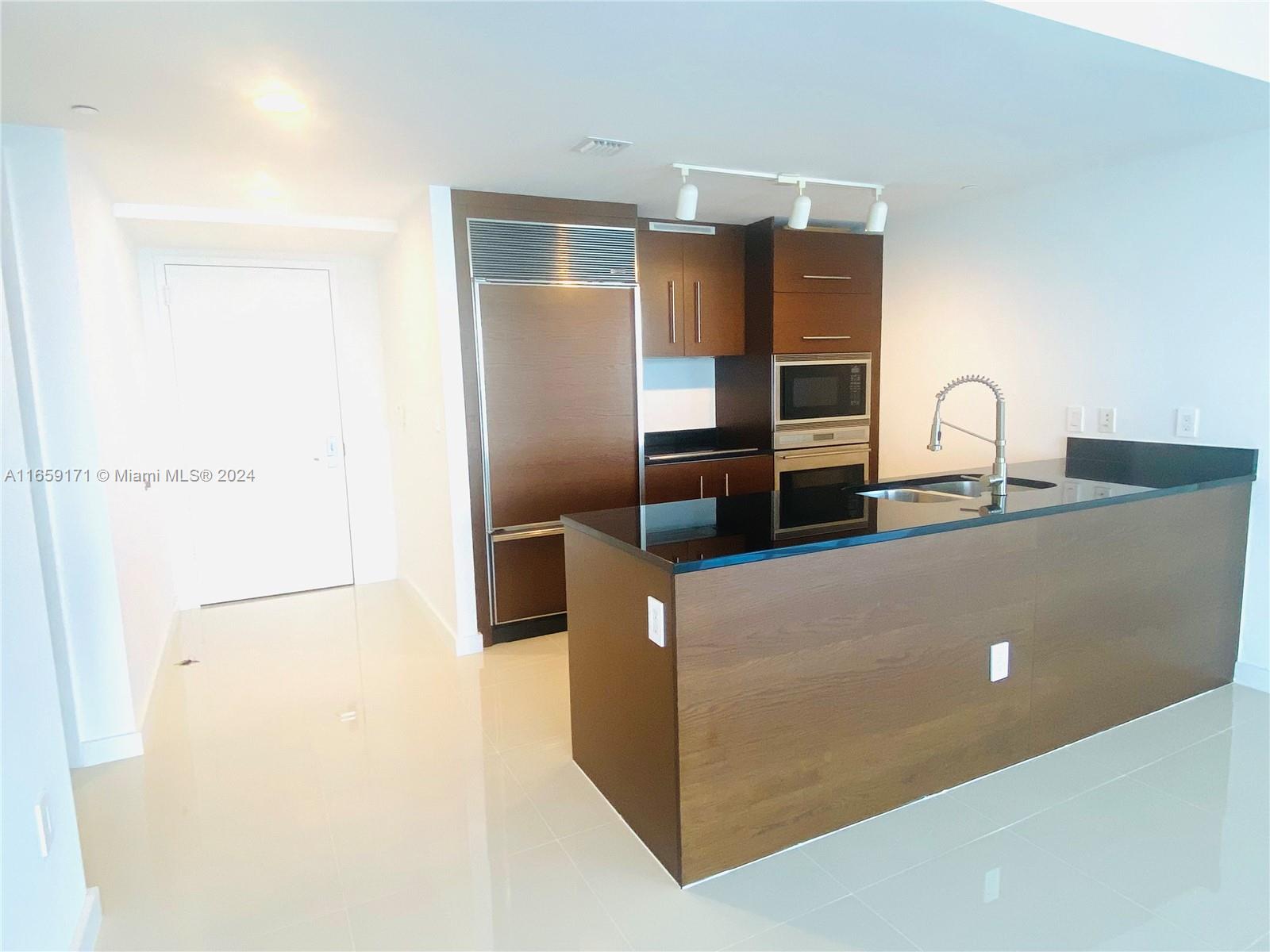 475 Brickell Avenue, Unit 4812 Miami, FL 33131 - Photo 3 of 20 a kitchen with stainless steel appliances a refrigerator and microwave