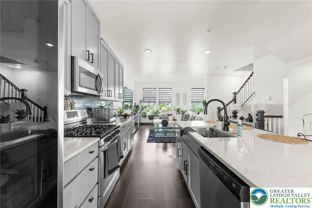 a kitchen with stainless steel appliances a sink stove and cabinets