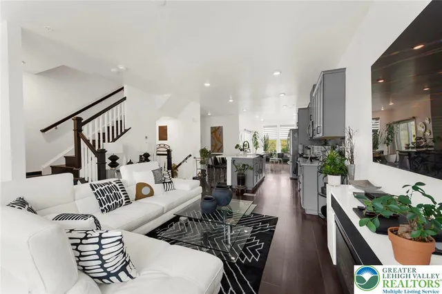 a living room with furniture kitchen view and a potted plant