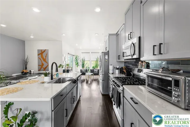 a kitchen with stainless steel appliances granite countertop a stove top oven a sink a counter space and cabinets