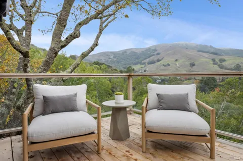 a balcony with outdoor seating and wooden floor
