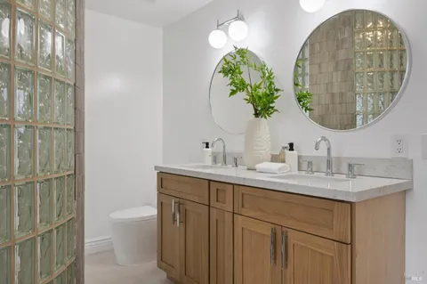 a bathroom with a sink and mirror with toilet