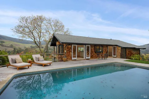 a view of a house with swimming pool and sitting area