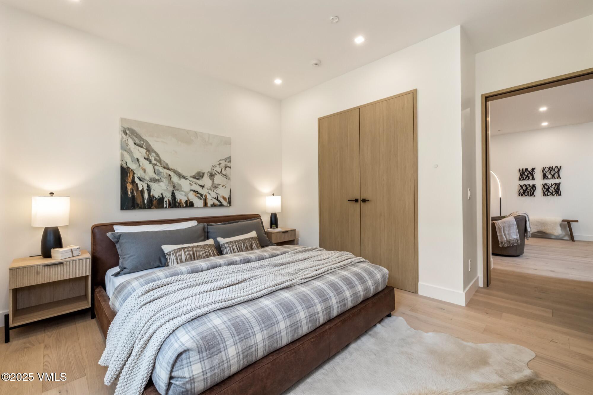 1489 Vail Valley Drive Vail, CO 81657 - Photo 38 of 56 a bedroom with a large bed and a chandelier