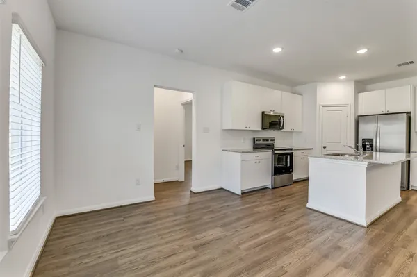 a kitchen with granite countertop a refrigerator and a stove top oven