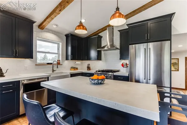 a kitchen with a sink a stove and chairs