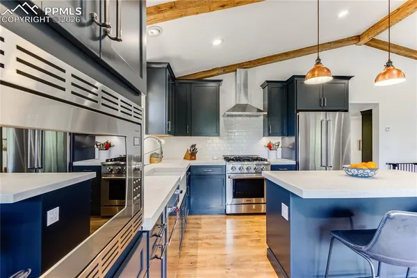 a large kitchen with stainless steel appliances granite countertop a stove and a refrigerator