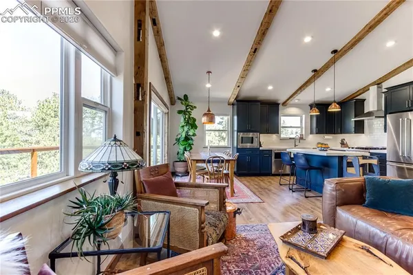 a living room with furniture kitchen and a large window