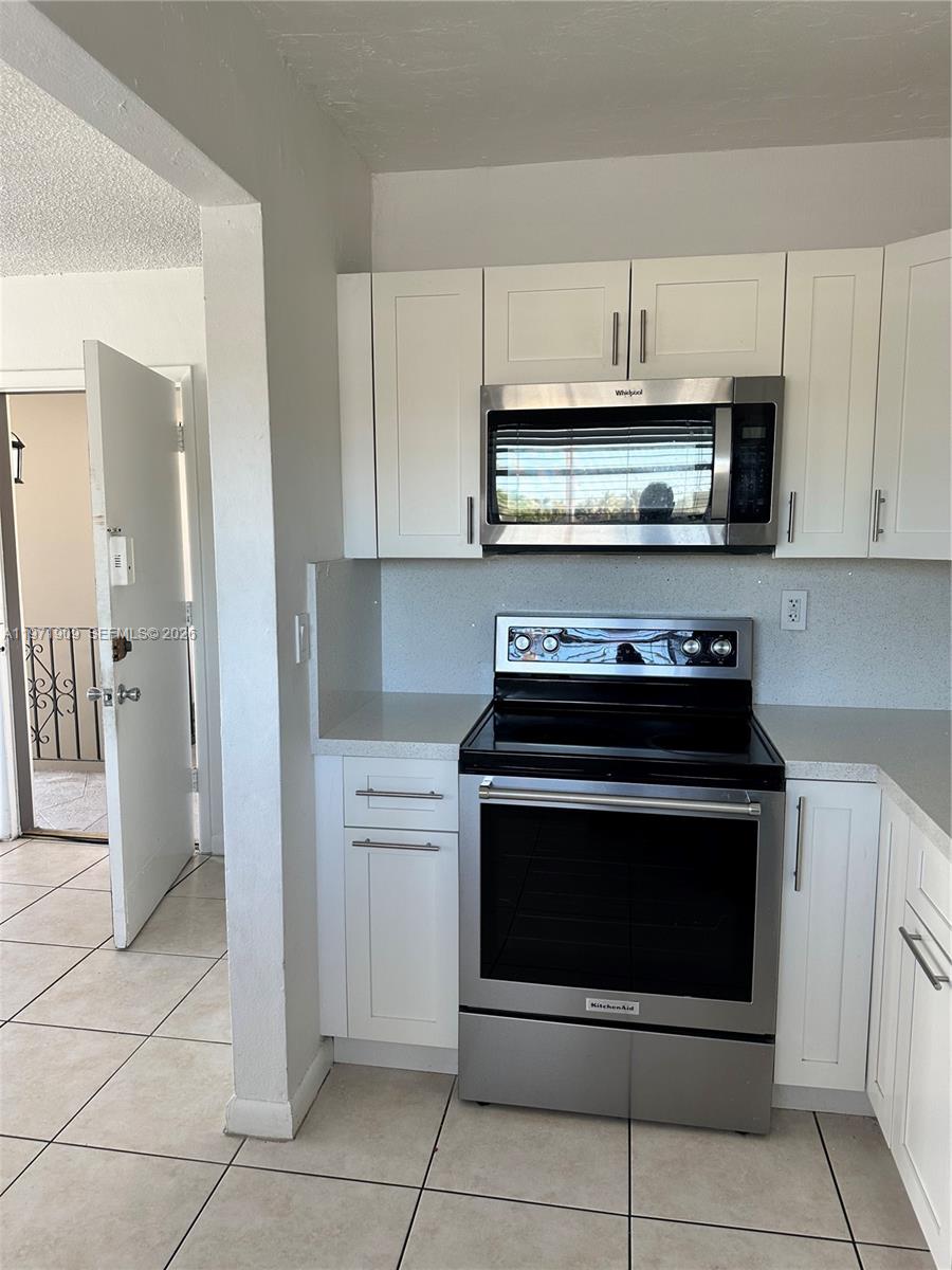 543 Southwest 37th Avenue, Unit 4 Miami, FL 33135 - Photo 5 of 12 a kitchen with cabinets and steel stainless steel appliances