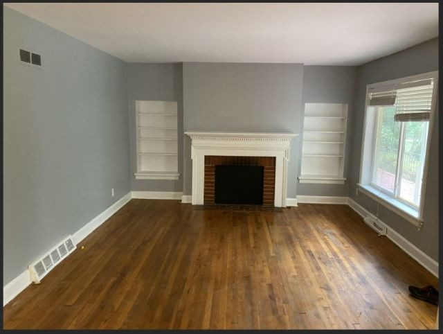 3003 Medlin Drive Raleigh, NC 27607 - Photo 3 of 7 a view of empty room with wooden floor and fireplace