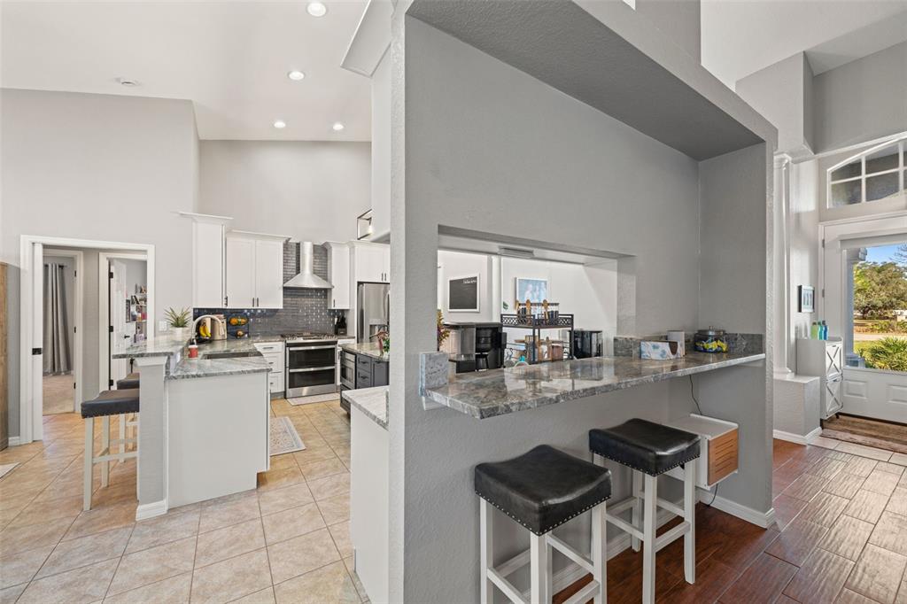 11180 Flock Avenue Weeki Wachee, FL 34613 - Photo 14 of 83 a kitchen with a dining table chairs and wooden floor