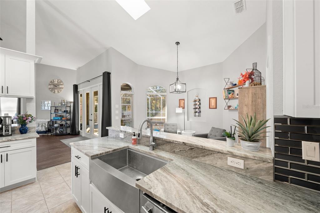 11180 Flock Avenue Weeki Wachee, FL 34613 - Photo 21 of 83 a kitchen with a stove a sink and a living room view